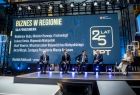 Uczestnicy debaty na scenie, w tle ekran z napisem "25-lecie Krakowskiego Parku Technologicznego"