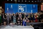 Pracownicy KPT stoją na scenie i pozują do wspólnego, pamiątkowego zdjęcia