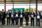 Uczestnicy uroczystości stoją w rzędzie