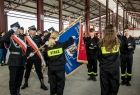 Strażacy stoją wokół sztandaru