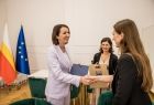 Marta Malec-Lech z zarządu województwa w gabinecie wręcza upominek laureatce.