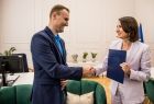 Marta Malec-Lech z zarządu województwa w gabinecie wręcza upominek laureatowi.