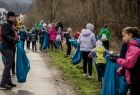 Grupa dzieci idzie przez park z workami na śmieci