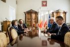 Uczestnicy spotkania siedzą przy stole konferencyjnym