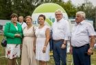 Pamiątkowe zdjęcie uczestników wydarzenia na tle zieleni