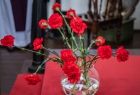 Widok na wazon wypełniony czerwonymi kwiatami. 