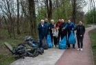 Ochotnicy stoją na ścieżce obok sterty zebranych śmieci