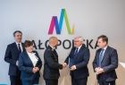 Wicemarszałek Józef Gawron gratuluje mężczyźnie w garniturze. Obok pozostali przedstawiciele Sejmiku.