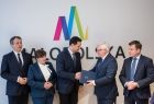 Wicemarszałek Józef Gawron w geście uścisku dłoni z mężczyzną w garniturze. Obok pozostali przedstawiciele Sejmiku.