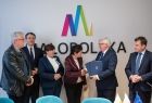 Wicemarszałek Józef Gawron trzymający pięć granatowych teczek. Obok przedstawiciele Sejmiku.