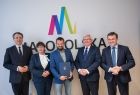 Mężczyzna w granatowym garniturze w kratę z przedstawicielami Sejmiku. 