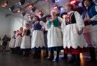 Widok na kobiety stojące w rzędzie w tradycyjnych strojach ludowych. Kobiety są w trakcie występu.