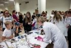 Dzieci z zachwyconymi minami przyglądają się eksperymentom naukowym