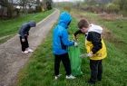 Dzieci zbierają śmieci z alejki i trawnika