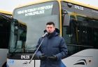 Łukasz Smółka na tle autobusu