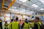 Przedstawiciel firmy oprowadza po hali zakładowej grupę osób
