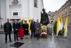 Grupa osób, w tym Iwona Gibas z zarządu województwa i radna województwa Danuta Kawa, stoi przed pomnikiem Papieża Polaka w Wadowicach
