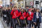 Harcerze maszerujący przez miasto czwórkami z solidnymi kosturami w rękach