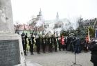 Młodzi ludzie w strojach powstańców oddają salwę honorową z historycznej broni