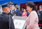 Radna Jadwiga Wójtowicz przekazuje strażakowi z OSP Srebrny Medal Polonia Minor.