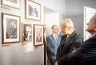 uczestnicy otwarcia oglądają zdjęcia Kornela Makuszynskiego wiszące na ścianie jego muzeum