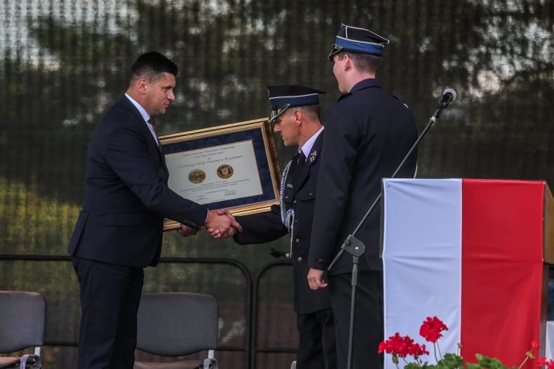 Wicemarszałek Łukasz Smółka przekazuje prezesowi OSP Kryspinów Złoty Medal Polonia Minor.