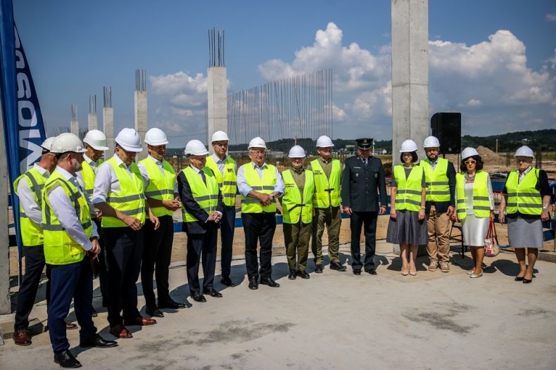 Uczestnicy wydarzenia stoją na placu budowy.