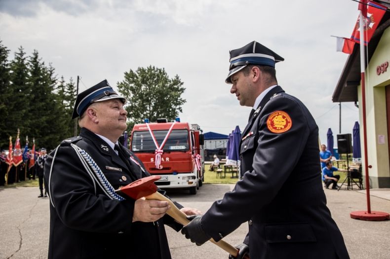 Wicemarszałek Łukasz Smółka przekazuje toporek prezesowi OSP.