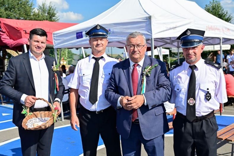 Minister Andrzej Adamczyk i wicemarszałek Łukasz Smółka stoją ze strażakami.