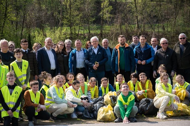 Dzieci, młodzież i zaproszeni goście po akcji sprzątania pozują do pamiątkowego zdjęcia