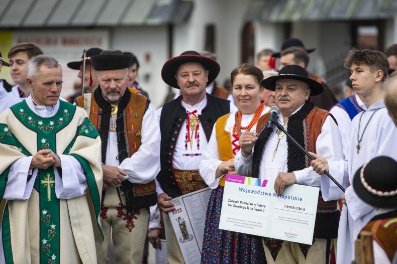 górale uczestniczący w poświęceniu stada owiec przed rozpoczęciem sezonu. Na głównym widoku Jan Piczura wiceprzewodniczący Sejmiku trzymający symboliczny czek - 2 mln od Marszałka na kulturowy wypas owiec