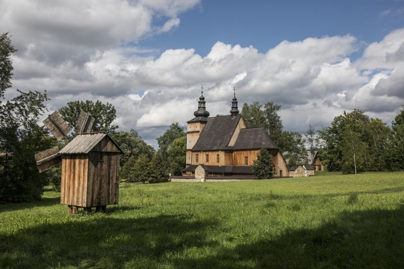 drewniany kościół z Łososiny Dolnej w Sądeckim Parku Etnograficznym, z lewej strony widoczny drewniany wiatrak