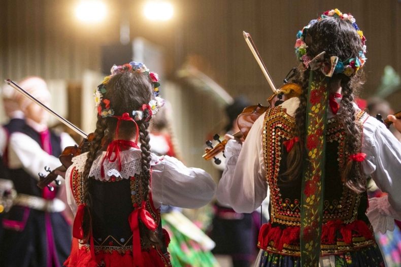 dwójka dzieci stająca tyłem w strojach regionalnych