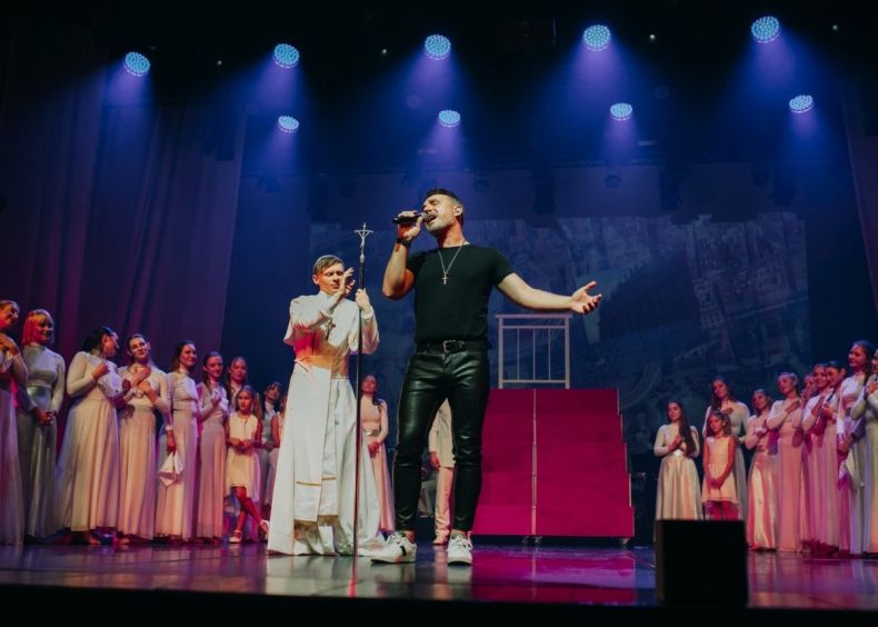 grupa osób na scenie. Jedna osoba w stroju papieża
