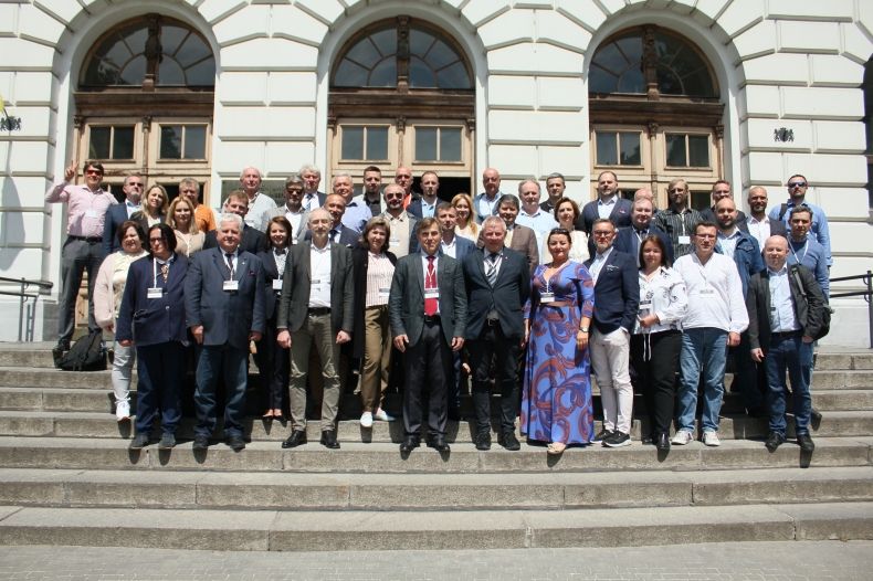 uczestniy konferencji stoją na schodach