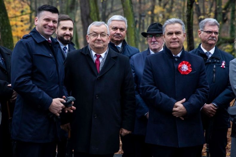 Wicemarszałek Łukasz Smółka stoi z ministrem Andrzejem Adamczykiem i innymi ludźmi.