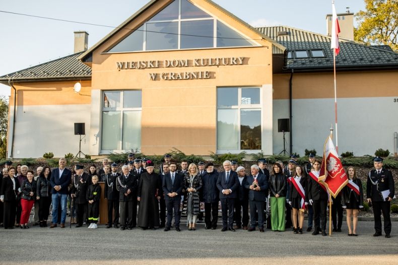 Pamiątkowe zdjęcie wszystkich uczestników wydarzenia na tle remizy OSP Grabno