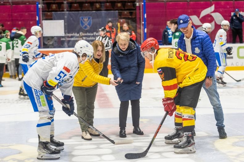 Uroczysta inauguracja meczu. Iwona Gibas z zarządu województwa oraz rektor prof. Sonia Grychtoł rzucają krążek na taflę, przed dwóch hokeistów przeciwnych drużyn