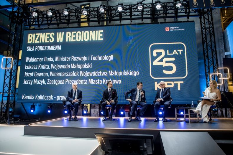 Uczestnicy debaty na scenie, w tle ekran z napisem "25-lecie Krakowskiego Parku Technologicznego"
