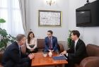 Wicemarszałek Witold Kozłowski siedzący przy stole kawowym z kobietą i dwoma mężczyznami w garniturach.