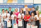 Wicemarszałek Józef Gawron z grupą dzieci z prezentami w rękach.