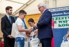 Wicemarszałek Józef Gawron wręcza prezent chłopcowi.