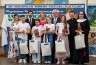 Wicemarszałek Józef Gawron z grupą dzieci i siostrą zakonną na scenie.