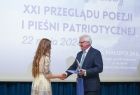 Wicemarszałek Józef Gawron gratuluje dziewczynie w jasnej sukience.
