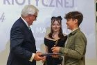 Wicemarszałek Józef Gawron wręcza nagrodę chłopcowi.