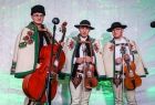 Kapela góralska. Trzech młodych ludzi w strojach góralskich trzymających skrzypce
