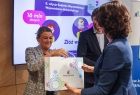 Członek zarządu Marta Malec-Lech wręcza ozdobną torbę kobiecie.