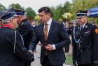 Wicemarszałek Łukasz Smółka podaje rękę strażakowi.
