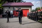 Wicemarszałek Łukasz Smółka maszeruje po placu. Po prawej widoczne poczty sztandarowe.