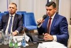 Marszałek Łukasz Smółka trzyma mikrofon.